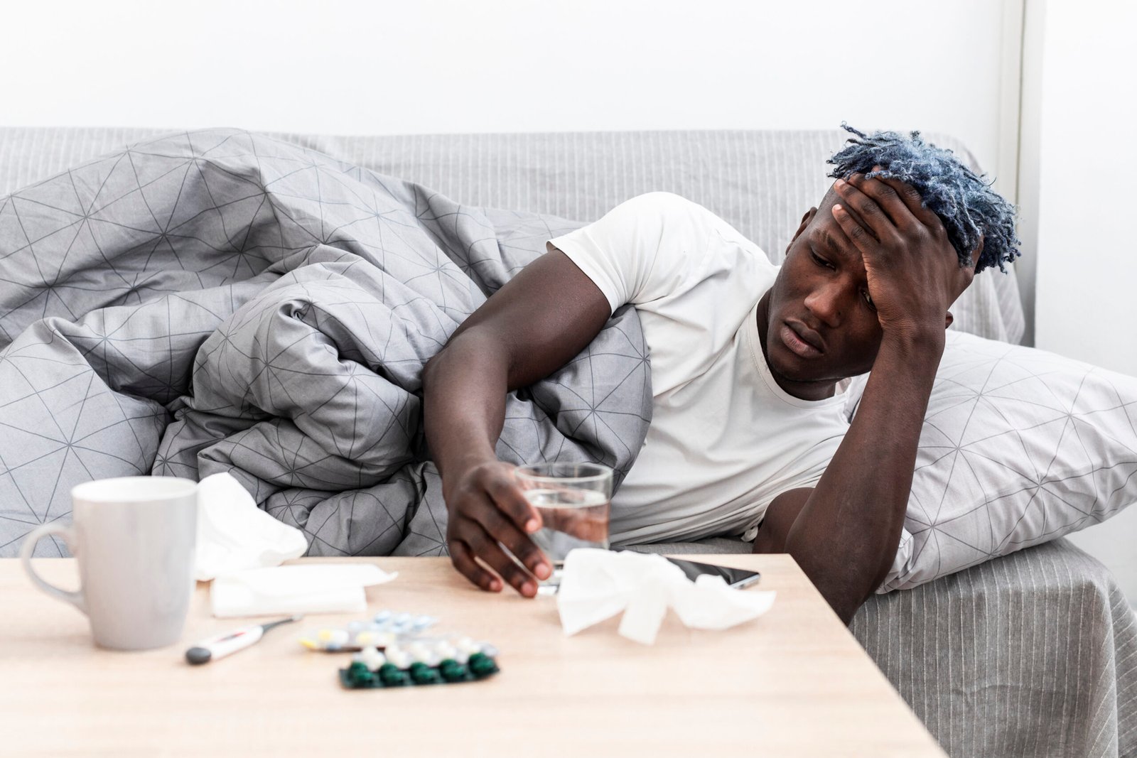 a man resting on a chair with manypill on his table